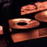 Due schede grafiche moderne posizionate su una scrivania da gaming con monitor acceso sullo sfondo