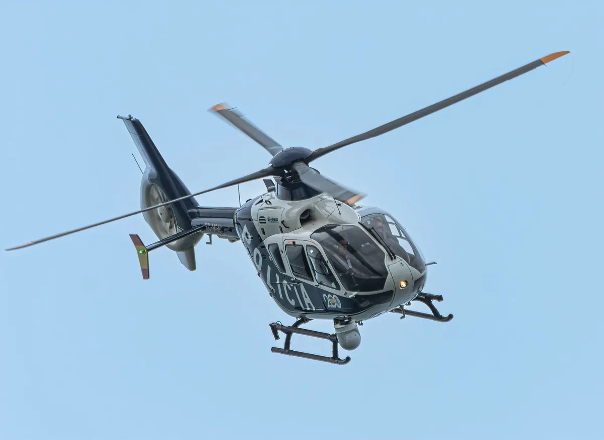 Drone della polizia in volo sopra una strada urbana con vista aerea della zona