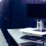 Ambiente di lavoro tecnologico con schermi che mostrano visualizzazioni di modelli IA e infrastrutture server