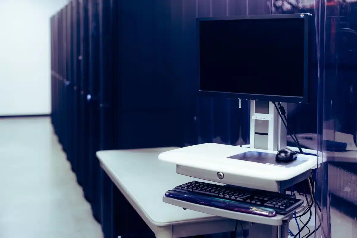 Ambiente di lavoro tecnologico con schermi che mostrano visualizzazioni di modelli IA e infrastrutture server