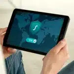 Smartphone che mostra video crittografati con telecamera di sicurezza sullo sfondo