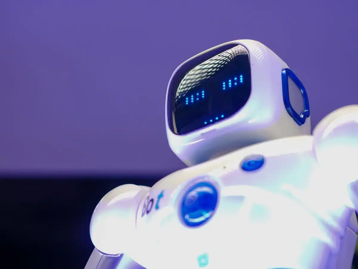 Mani su tastiera di laptop con grafici di dati e visualizzazioni di intelligenza artificiale sullo sfondo