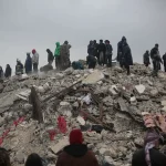 Detriti e macerie di un edificio crollato con spazi stretti dove operano i soccorsi di emergenza
