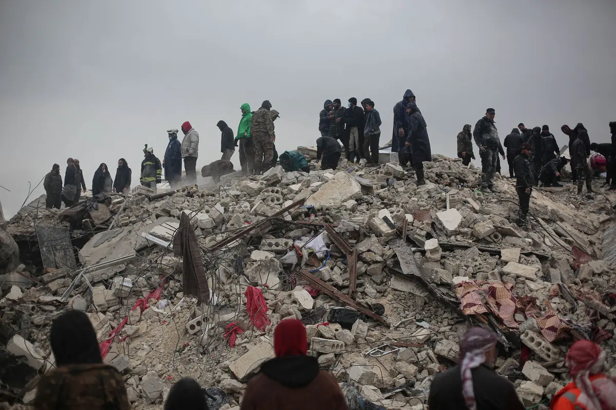 Detriti e macerie di un edificio crollato con spazi stretti dove operano i soccorsi di emergenza