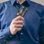 Carta di credito scaduta frammentata con simboli di sicurezza digitale e reti di pagamento sullo sfondo