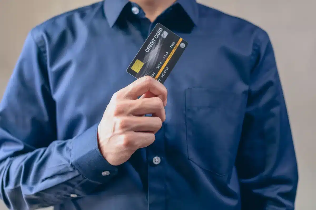 Carta di credito scaduta frammentata con simboli di sicurezza digitale e reti di pagamento sullo sfondo