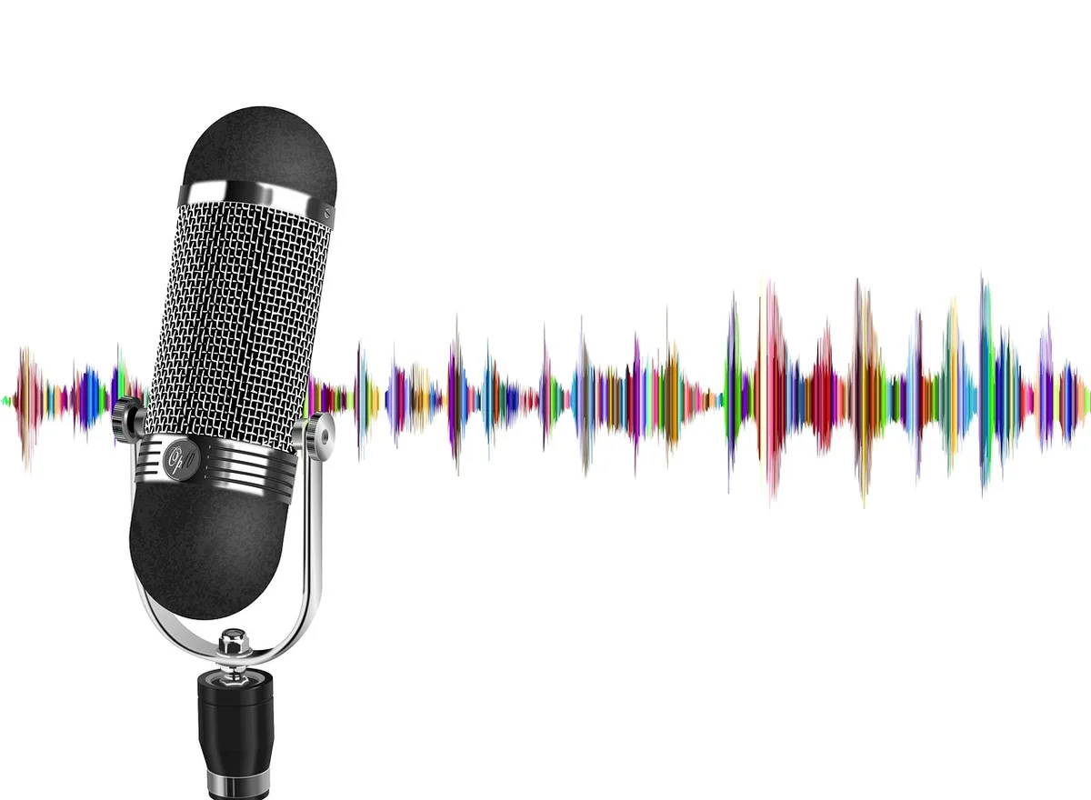 Mani anonime che modificano forma d'onda audio su uno schermo di computer con cuffie e visualizzazione delle onde sonore
