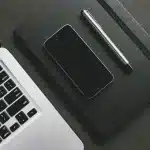 Mani anonime che digitano su una tastiera di laptop con finestra del terminale Linux illuminata sullo schermo