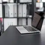 Scrivania con scheda grafica anonima e monitor che mostra grafici dei prezzi delle GPU