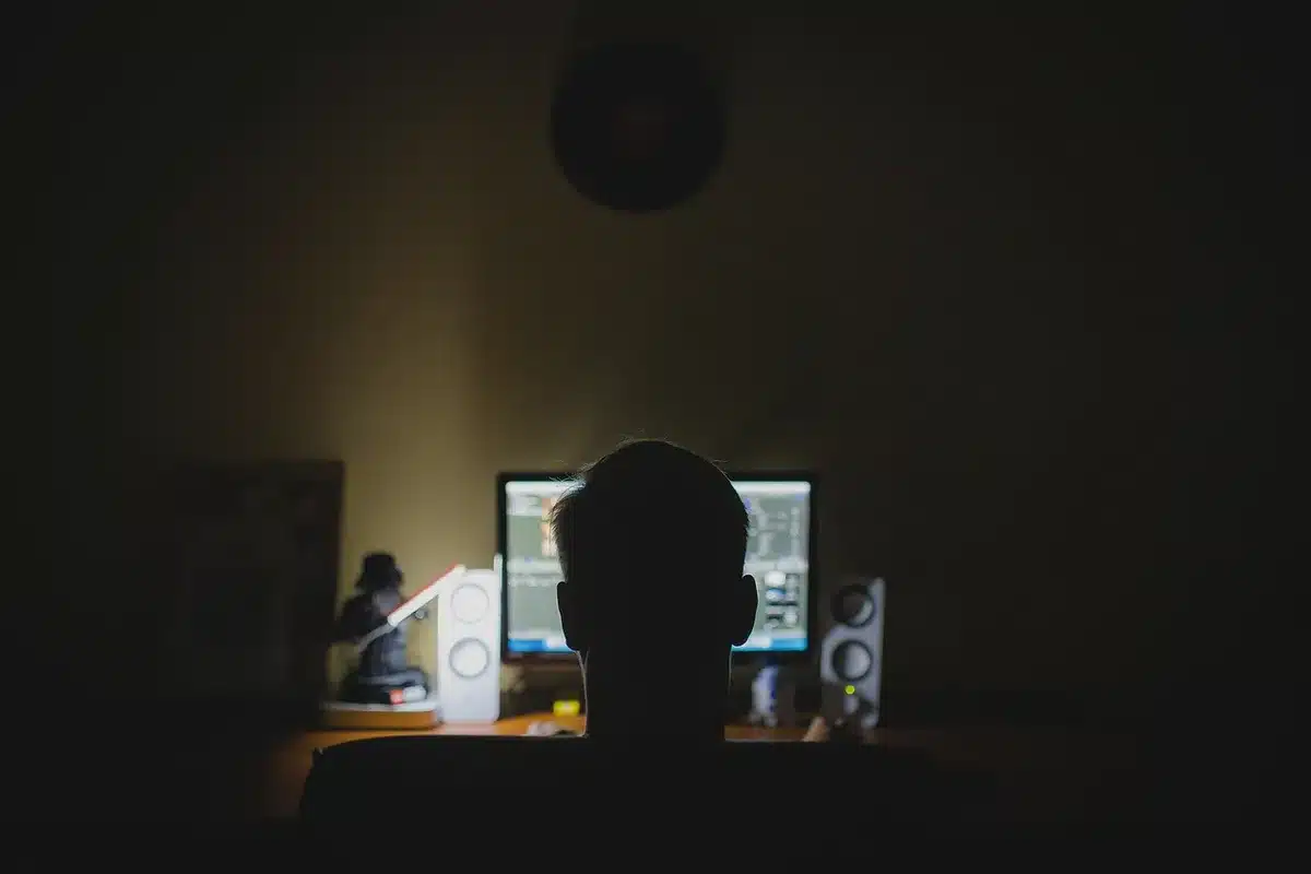 Mani anonime che scrivono al computer con fogli di formule matematiche sul tavolo