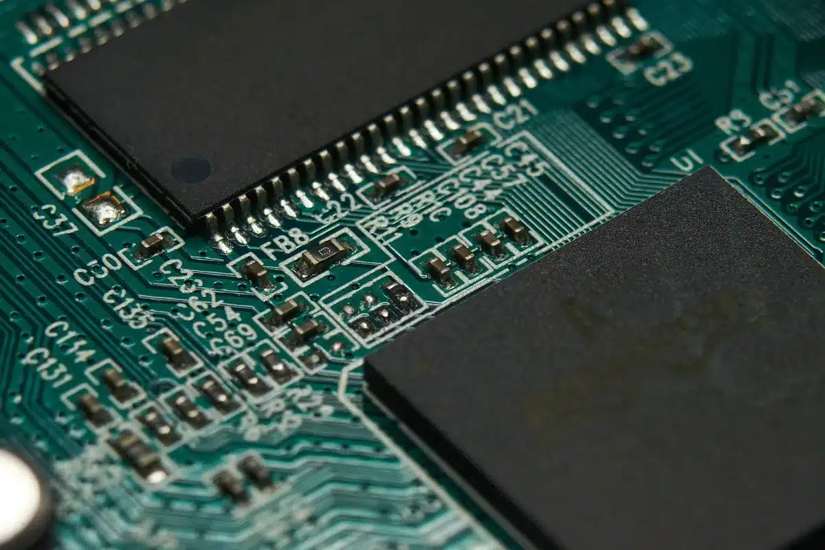 Primo piano anonimo di una scheda GPU prototipo e moduli memoria su un tavolo da laboratorio