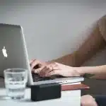 Sala server e laptop con foglio di calcolo in ufficio, persone sullo sfondo non riconoscibili