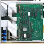 Banco di lavoro con componenti PC e mani che esaminano una scheda grafica anonima