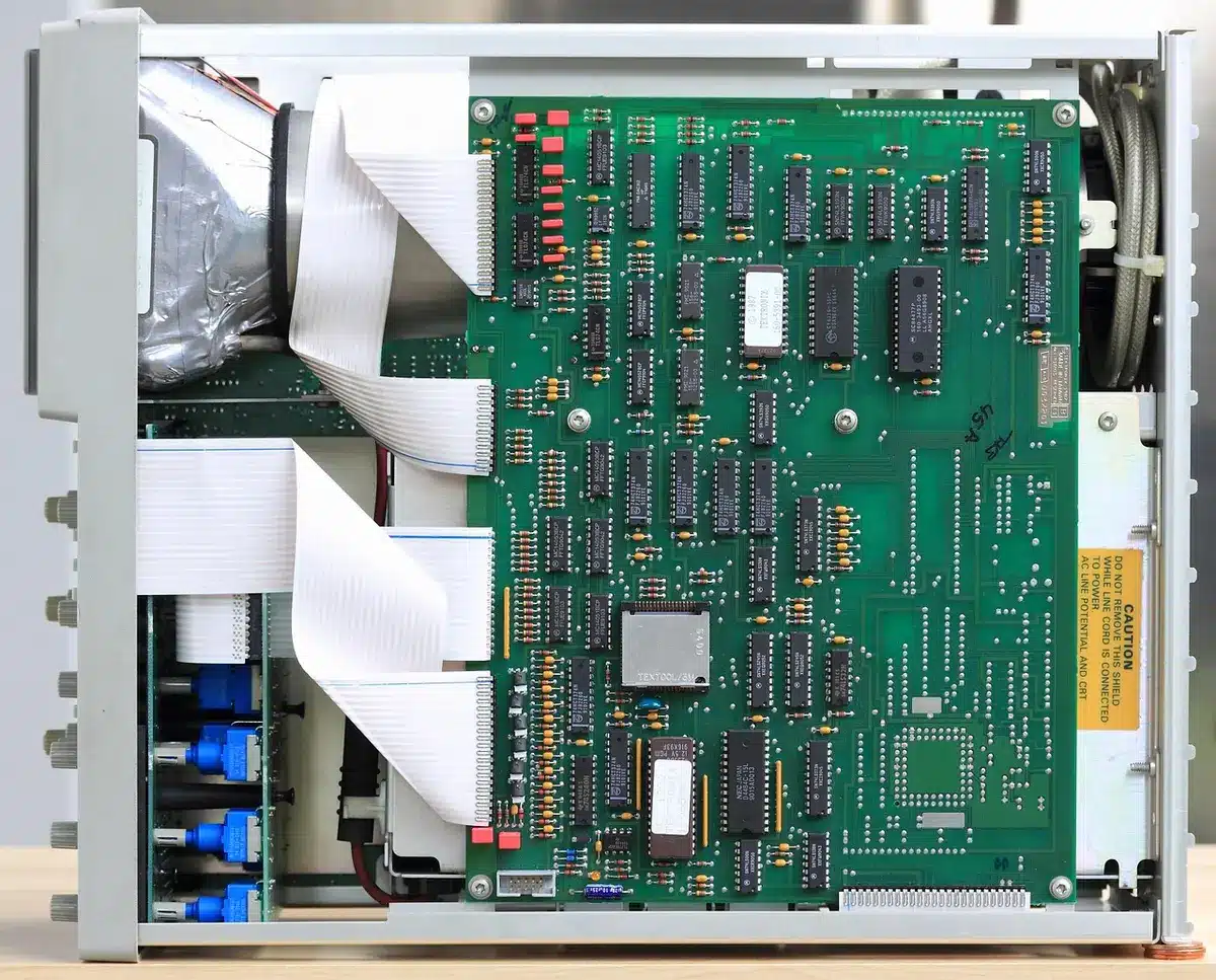 Banco di lavoro con componenti PC e mani che esaminano una scheda grafica anonima