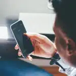 Scrivania con laptop chiuso, smartphone e ricevuta di viaggio in luce naturale