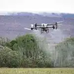 Silhouette di droni e sensori in un campo che evocano reti autonome militari
