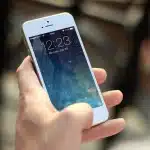 Persona anonima usa uno smartphone in una caffetteria per gestire un abbonamento